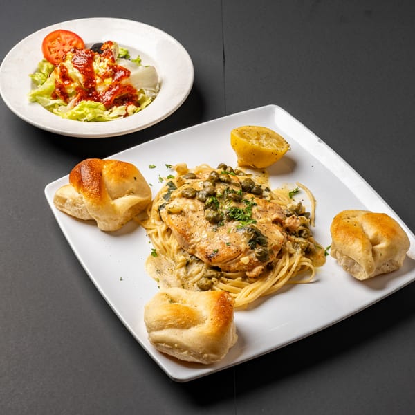 Bella's Italian Restaurant's chicken piccata with spaghetti, garlic knots, and a side salad.